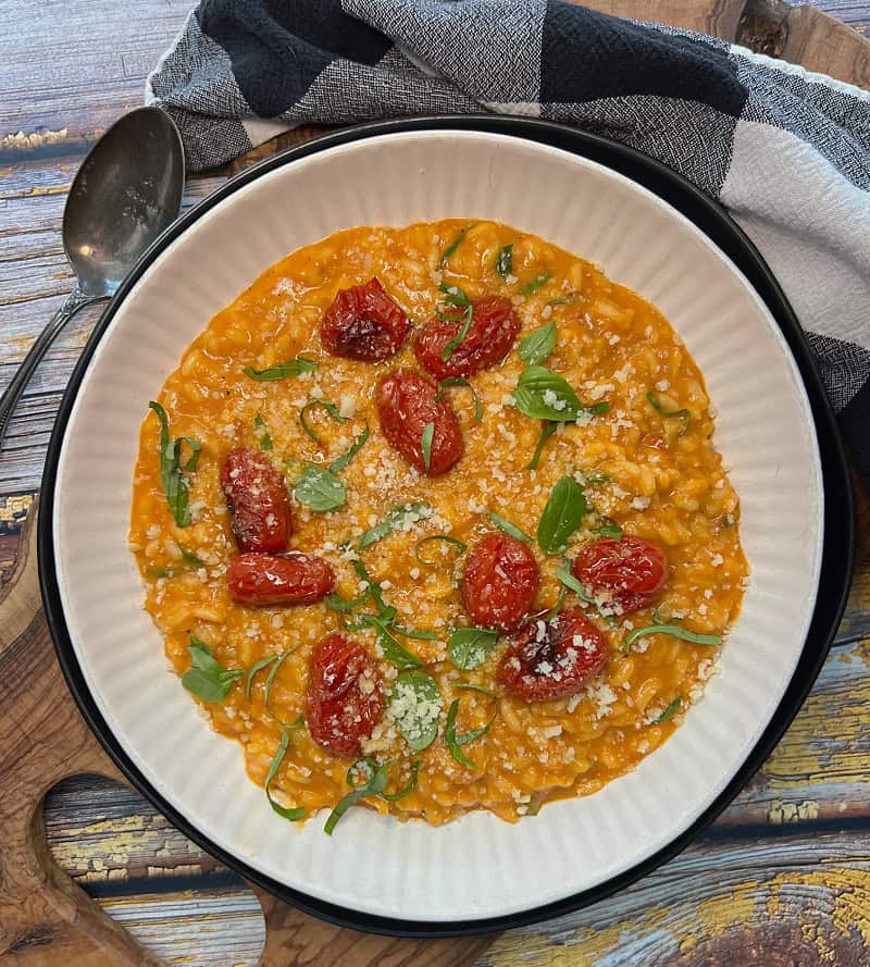 overhead view roasted tomato risotto in shallow white bowl