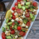white rectangular platter with chickpea salad with tomatoes and cucumbers