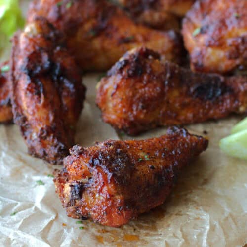 closeup of one crispy baked wing with others in the background