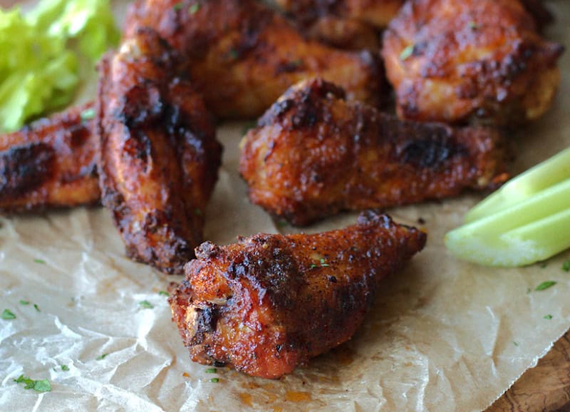 closeup of one crispy baked wing with others in the background