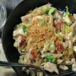 black bowl with cheesy chicken pasta with brussels sprouts topped with crispy panko breadidng