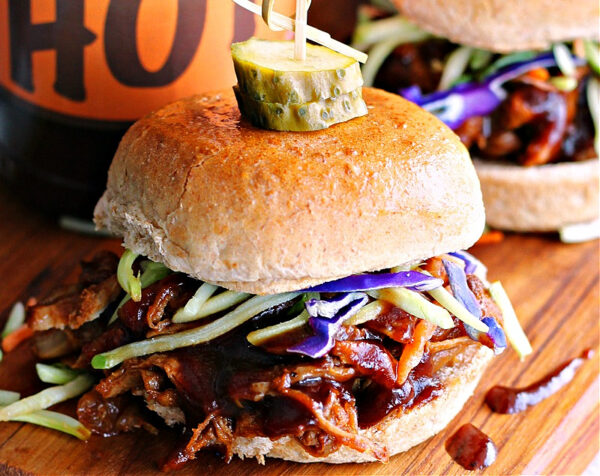closeup of slow cooker pulled pork sliders topped with coleslaw.