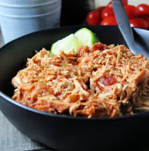 black bowl filled with shredded slow cooker salsa chicken