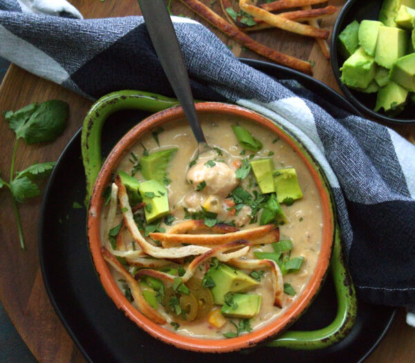 overhead view - slow cooker white chicken chili in orange and green bowl