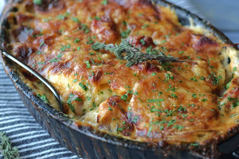closeup black casserole dish with scalloped potatoes and ham