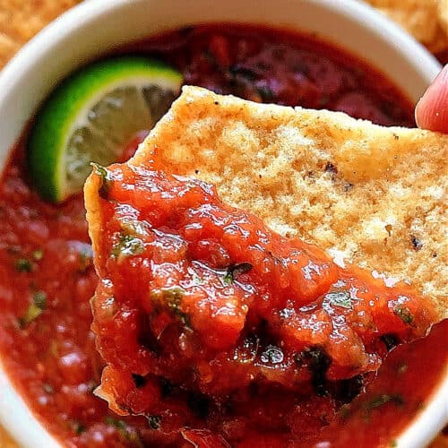 restaurant salsa in a bowl with tortilla chip scooping some out