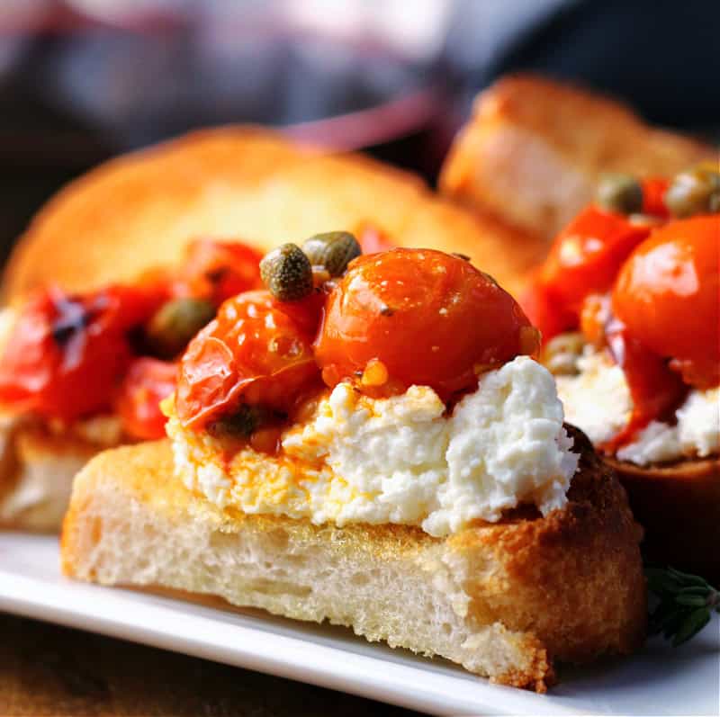 toasted baguette topped with baked goat cheese tomato dip