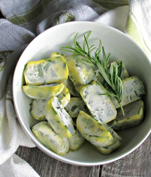 white bowl with herbs frozen in olive oil in cubes - how to preserve fresh herbs