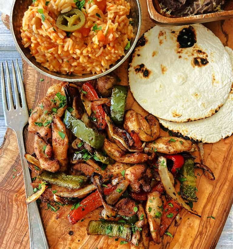wood board with air fryer chicken fajitas and vegetables