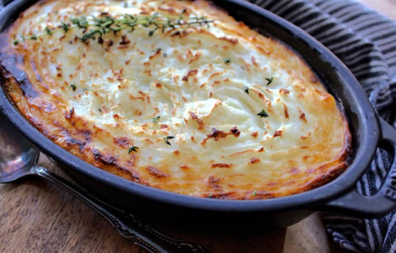 black casserole dish with easy shepherd's pie garnished with fresh parsley