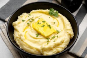 black bowl with smoked gouda mashed potatoes and a pat of butter on top