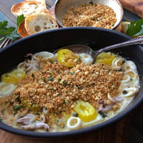 black serving dish with sauteed calamari topped with crispy breadcrumbs