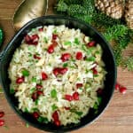 black bowl with christmas rice studded with pomegranate seeds and garnished with parsley