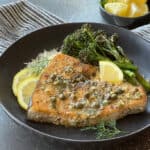 black bowl with baked lemon garlic swordfish drizzled with garlic butter served with rice and broccoli