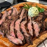 how to cut steak against the grain - sliced skirt steak shown with dollop of compound butter