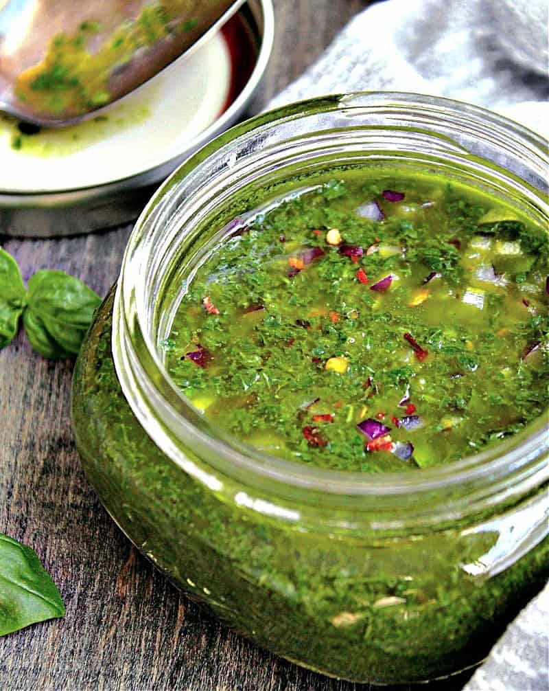 mason jar with bright chimichurri showing pesto and chimichurri