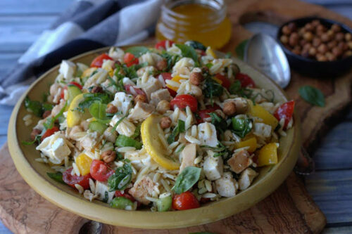 close up of yellow bowl with lemon chicken orzo salad