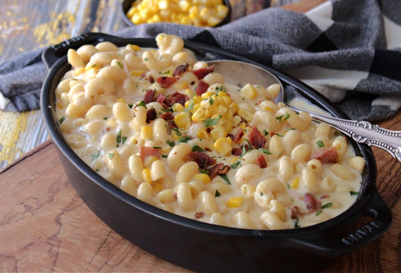 black casserole dish with smoked gouda mac and cheese with bacon and corn garnished with crispy bacon