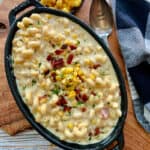 overhead view - black casserole dish with smoked gouda mac and cheese garnished with crispy bacon