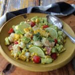 yellow bowl with old bay shrimp salad with avocado, tomatoes and charred corn