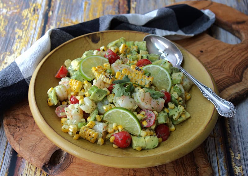 yellow bowl with old bay shrimp salad with avocado, tomatoes and charred corn