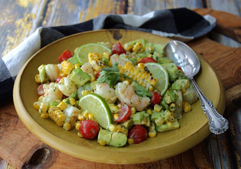 yellow bowl with old bay shrimp salad with avocado, tomatoes and charred corn.
