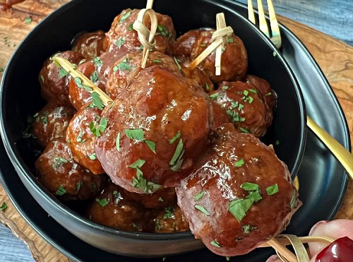 closeup of two meatballs on a skewer