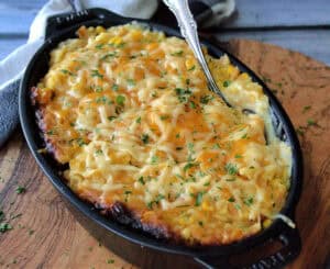 overhead view black serving dish with Crock Pot Corn Casserole and spoon scooping out