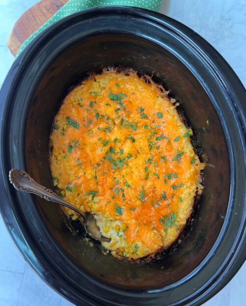 overhead view of crock pot corn casserole garnished with parsley
