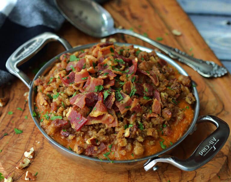 stainless steel baking dish with creamy mashed sweet potatoes topped with bacon and brown sugar crumble