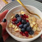 bowl of slow cooker oatmeal showing a hand on the side of the bowl