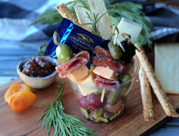 closeup of individual charcuterie cups and breadsticks on the side