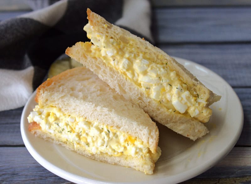 egg salad sandwich using air fryer hard boiled eggs sliced on the diagonal on a white plate