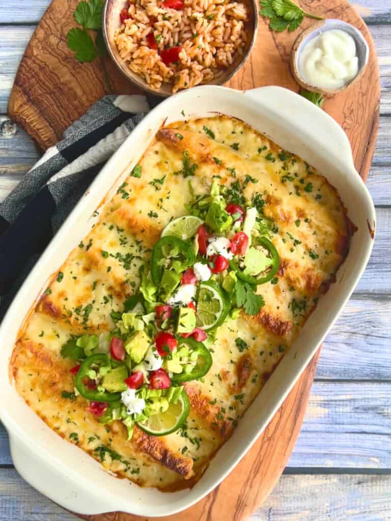 overhead view white chicken enchiladas in white casserole dish.