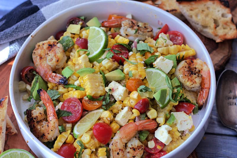 overhead view of corn salad served as a meal with grilled shrimp