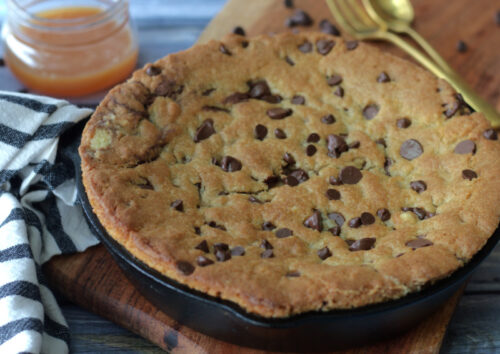 overhead view skillet chocolate chip cookie in cast iron skillet. Hasn't been sliced yet