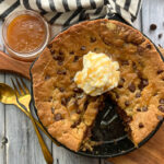 overhead view skillet chocolate chip cookie in cast iron skillet with scoop of vanilla ice cream
