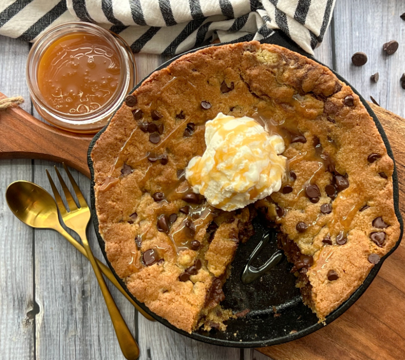 overhead view skillet chocolate chip cookie in cast iron skillet with scoop of vanilla ice cream