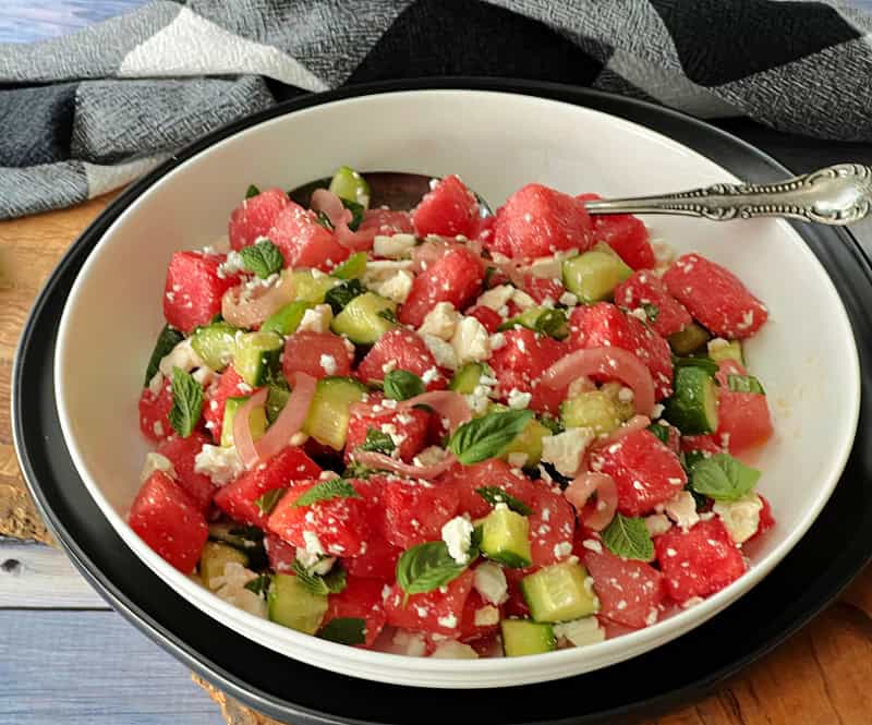 white bowl with watermelon feta salad and spoon in the bowl