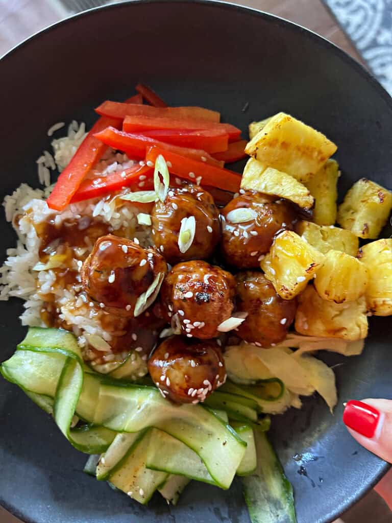 black bowl with air fryer meatballs teriyaki style
