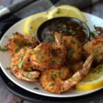 what to serve with coonut shrimp - white plate with shrimp garnished with lemons and parsley