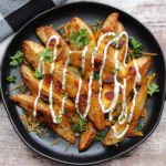 black plate with loaded potato wedges