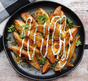black plate with loaded potato wedges