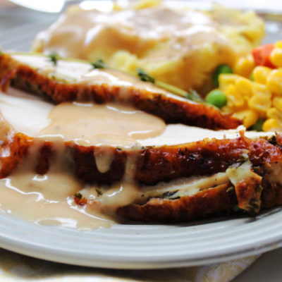 slices of air fryer turkey breast on a plate with potatoes and gravy
