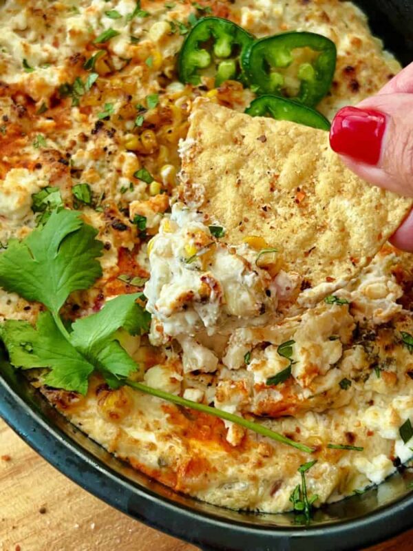 closeup of Mexican Street Corn Dip scooped on a tortilla chip