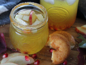 mason jars filled with thanksgiving apple cider sangria garnished with apple slices