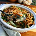 white casserole dish with small batch of green bean casserole topped with crispy onions