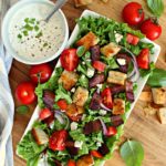 overhead view of white platter and blt salad
