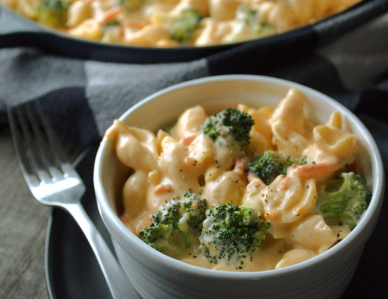 bowl of broccoli cheddar mac and cheese with pot in the background