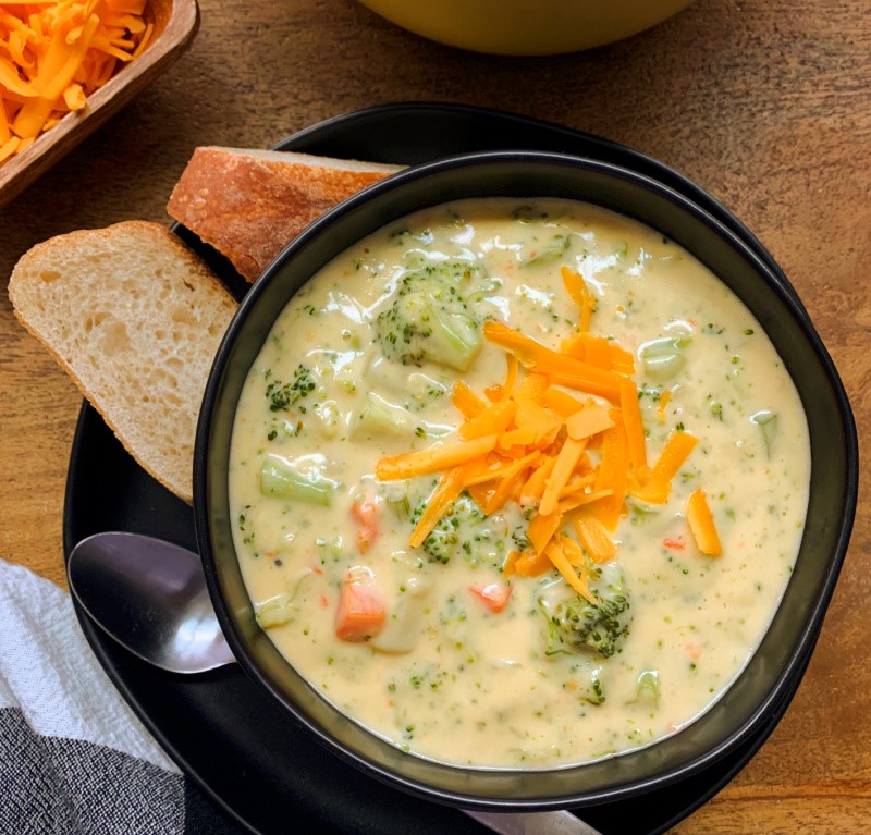 what to serve with broccoli cheese soup- overheadview of bowl of soup garnished with shredded cheese